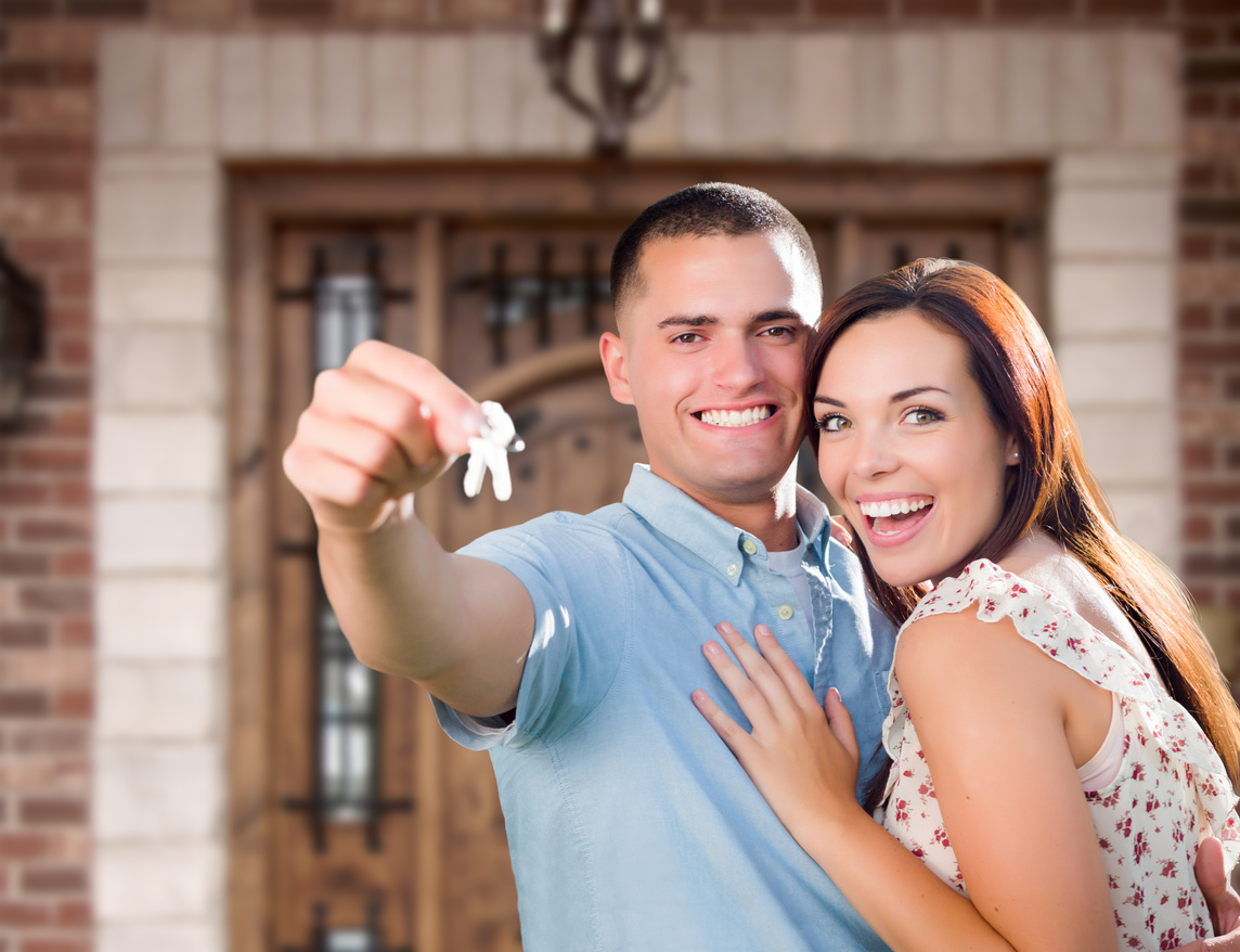 Young Couple Holding Keys to New House